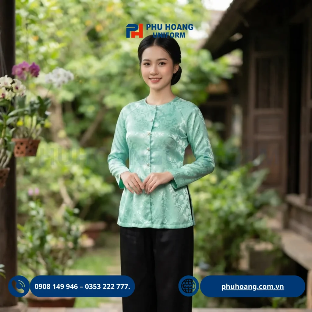 Hình ảnh sản phẩm áo bà ba đồng phục màu xanh ngọc do xưởng may Phú Hoàng trực tiếp thiết kế và sản xuất. Trang phục sở hữu chất liệu gấm chìm sang trọng, thoáng mát, form dáng chuẩn tôn vinh vóc dáng người mặc. Chúng tôi cam kết mức giá gốc tận xưởng không qua trung gian, miễn phí thiết kế logo, hỗ trợ đơn số lượng ít và bảo hành in thêu trọn đời. Liên hệ ngay Hotline 0353 222 777 để đặt may đồng phục chất lượng nhất!